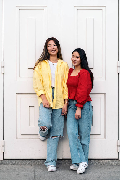 Happy young asian female friends smiling and looking at camera against white background. - Φωτογραφία, εικόνα