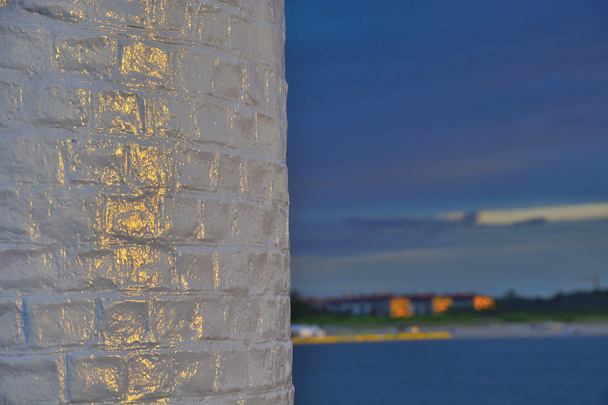 夕日に照らされた壁の灯台 - 写真・画像
