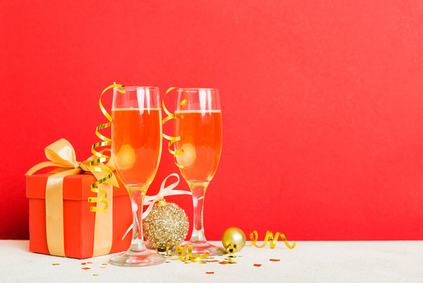 Champagne glasses and christmas decor on colored holiday background. Flat lay New Year decorations. - Zdjęcie, obraz