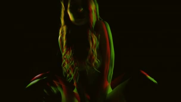 Beautiful female woman posing naked almost in shadow with soft blue and red lights on her - Video