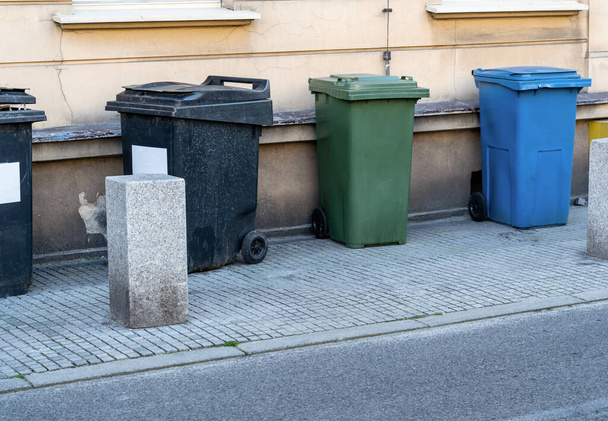 Siyah, mavi, sarı, yeşil çöp konteynırları. Atıkları ayır, çevre kavramını koru. Atıkları ayır, çöp kutularını ayır. Kağıt, plastik, cam ve organik renkli çöp tenekeleri. - Fotoğraf, Görsel