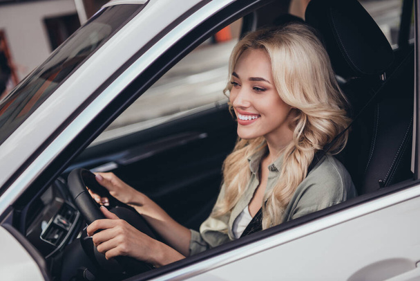 Portrait of pretty satisfied lady sitting car front seat hold wheel enjoy ride have good mood. - Photo, Image
