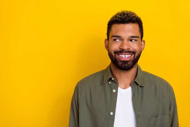 Photo of dreamy funky man wear khaki shirt looking empty space isolated yellow color background. - Foto, Imagen