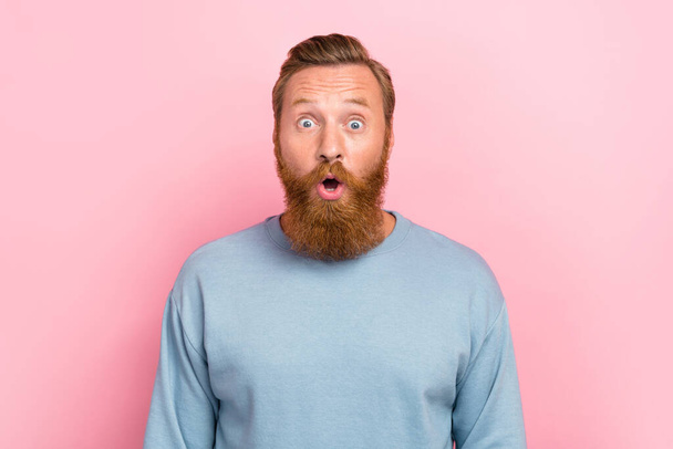 Photo of young redhair bearded handsome man wear blue jumper open mouth pouted lips shocked low prices isolated on pink color background. - Photo, Image