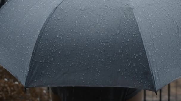 Rain on grey umbrella. Silver umbrella in the rain on evening Bangkok. Footage rain drops falling on umbrella. Represent bad weather winter rainy season or protection. Person and umbrella in the rain. - Footage, Video