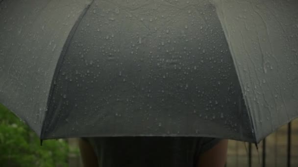Gri şemsiyeye yağmur yağıyor. Bangkok 'ta akşam yağmurunda gümüş şemsiye. Şemsiyeye düşen yağmur damlaları. Kötü kış yağmurlu mevsimi ya da korunmayı temsil ediyor. Yağmurda insan ve şemsiye. - Video, Çekim
