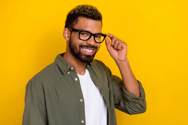 Photo of cheerful attractive man wear khaki shirt arms spectacles smiling isolated yellow color background. - Foto, Imagem