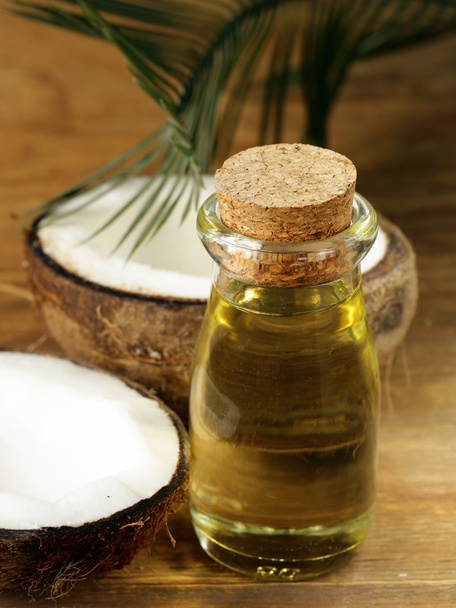 Coconut oil in a glass bottle and fresh nuts - Photo, Image