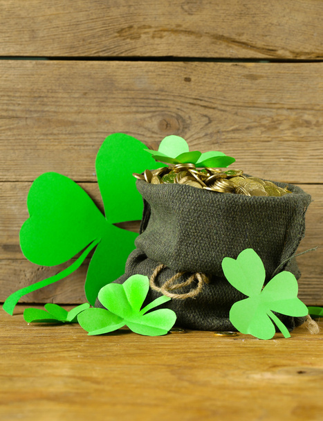 grüne Kleeblätter und ein Sack Gold - Symbol für den Tag des heiligen Patrick - Foto, Bild