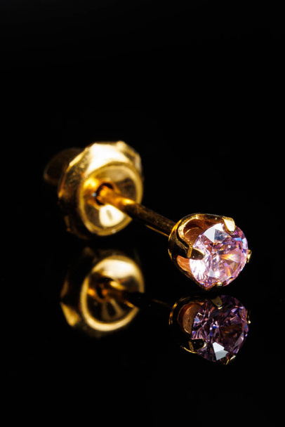 Joyería con pendientes de piedras, pendientes de oro de lujo con diamantes, joyas sobre fondo negro. - Foto, imagen