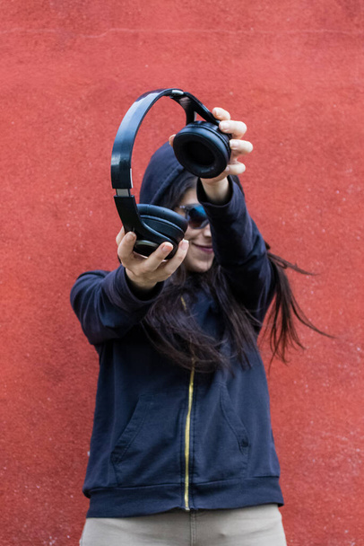 Frauen mit Kopfhörern vor roter Wand - Foto, Bild