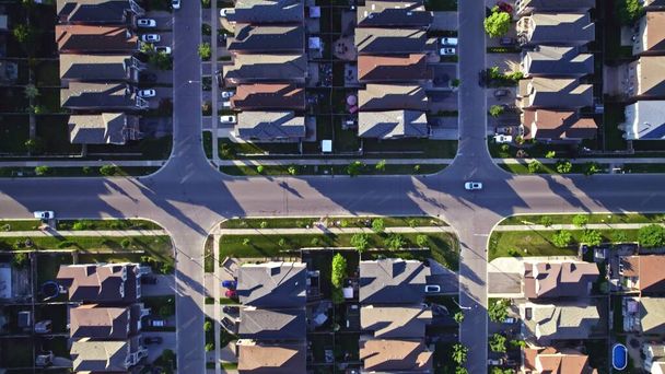 Aerial view of rich American citizens suburb at golden hour summer time. Established Real estate view of wealthy residential houses near greenery, parks and trees.  - Фото, зображення