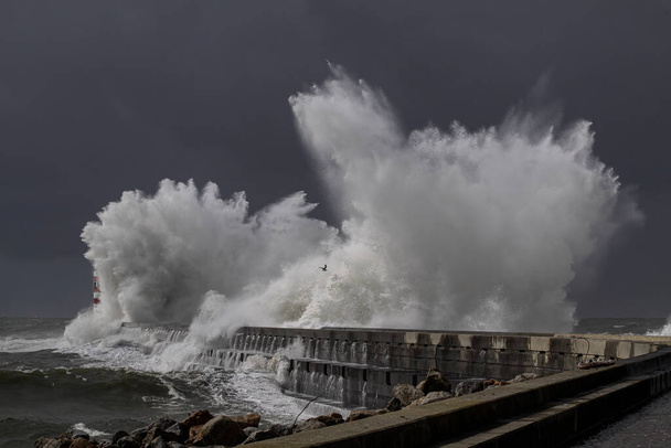 嵐の波のスプラッシュ。ドゥロ川の口の北桟橋とビーコン。ハリケーンの間 - 写真・画像