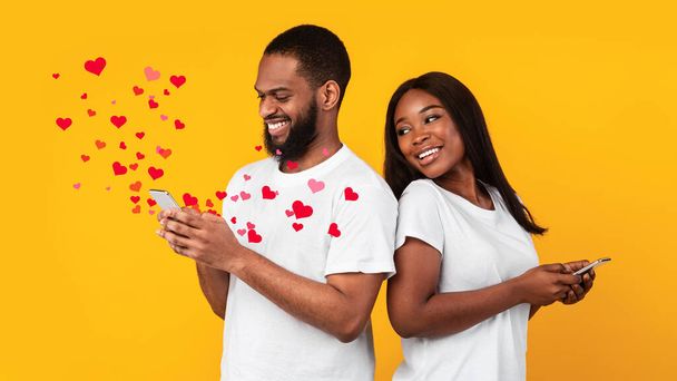 Portret wesołej pozytywnej pary Afroamerykanów stojących tyłem do siebie, trzymających i korzystających z telefonów komórkowych, uśmiechnięta czarna kobieta patrząca na gadżet swoich chłopaków, wysyłająca wiadomość miłosną, kolaż - Zdjęcie, obraz