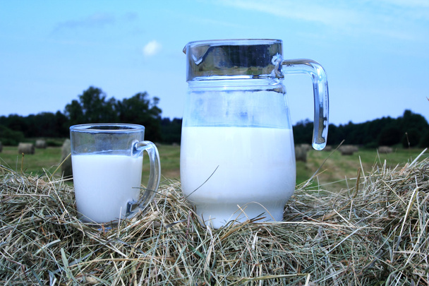 Foto van melk en glas op de hooiberg - Foto, afbeelding
