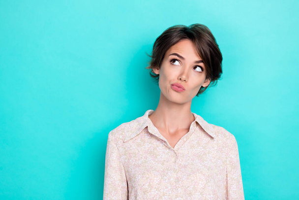 Photo of young adorable perfect gorgeous funny girl grimace pouted lips minded looking empty space interested new ad isolated on cyan color background. - Photo, image