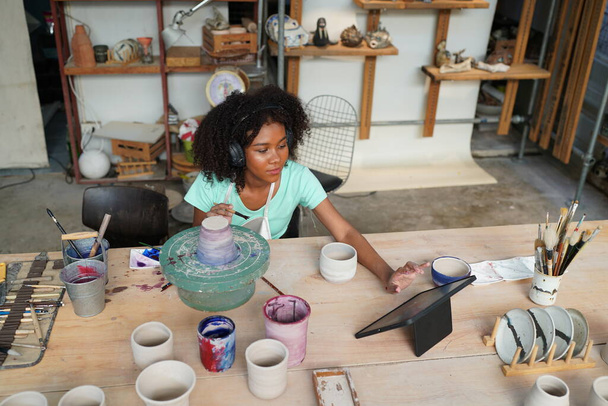 Young Afro girl hand potter making clay vase in pottery workshop, Business owner.  - Photo, Image