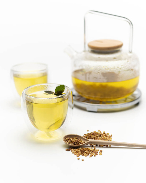 Piwo herbaciane parzona gryka, Ku Qiao, w szklanych filiżanek i czajniczek na białym tle - Zdjęcie, obraz