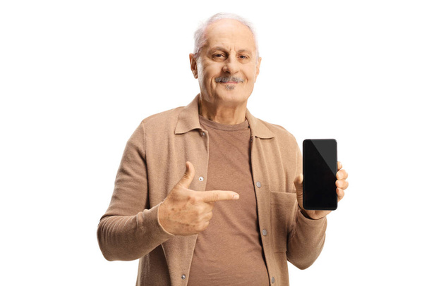 Mature man pointing at a smartphone device isolated on white background - 写真・画像