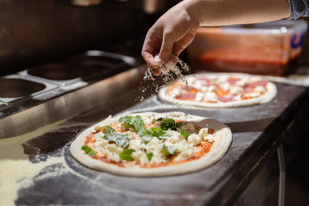 Pizza dělá proces. Mužské kuchařské ruce dělat autentickou pizzu v kuchyni pizzerie. - Fotografie, Obrázek