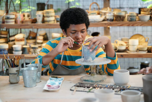 Kreatív fazekas művész vagy vállalkozó portréja kerámiatermékekkel a fazekasműhelyben - Fotó, kép