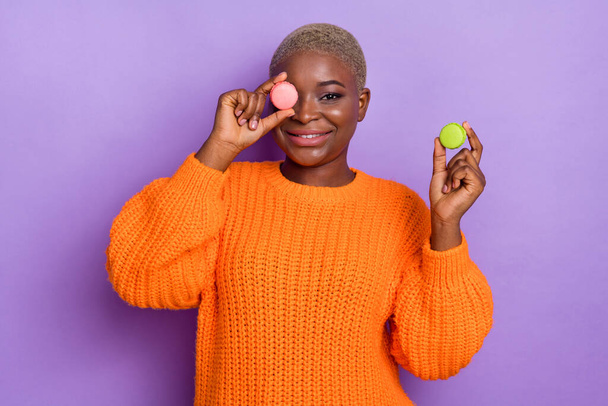 Fotografia miła młoda kobieta makaron okładka oko mają dobry nastrój nosić modny jesień pomarańczowy dzianina sweter izolowany na fioletowy kolor tła. - Zdjęcie, obraz