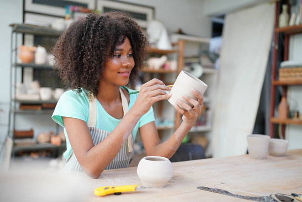 Nuori Afro tyttö käsi Potter tehdä savi maljakko keramiikka työpaja, Yrityksen omistaja.  - Valokuva, kuva