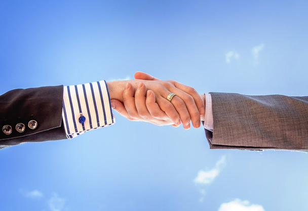 closeup podnikání handshake nad pozadí oblohy - Fotografie, Obrázek