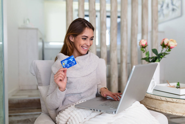 Фото, показывающее красивую женщину, делающую покупки онлайн с помощью кредитной карты. женщина с кредиткой и ноутбуком. Концепция покупок - Фото, изображение