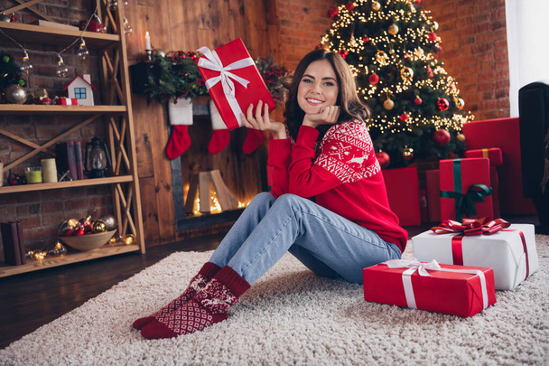 Full length photo of cute adorable person sit floor hands touch cheeks wear warm socks newyear decor house indoors. - Foto, afbeelding