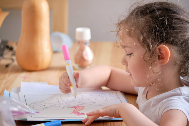Bambina che gioca con inchiostro invisibile e libro da colorare - Foto, immagini