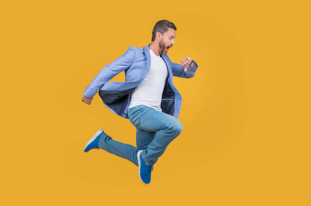 Businessman hurry being late. Shocked late businessman checking time in midair. late businessman checking time isolated on yellow studio background. - Fotoğraf, Görsel