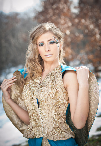 Прекрасная юная леди в элегантном платье позирует зимние пейзажи, королевский вид. Модная блондинка с лесом на заднем плане, открытая съемка. Гламурная женщина с длинными светлыми волосами в природе - стиль принцессы
 - Фото, изображение