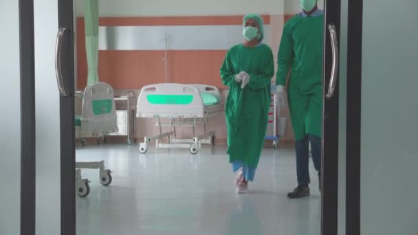 Χειρούργος ομάδας σε ομοιόμορφη χειρουργική επέμβαση επιτυχίας και το περπάτημα βγαίνουν από το χειρουργείο στο νοσοκομείο, ομάδα της ομαδικής εργασίας γιατρός με τα πόδια βγαίνουν από τα επείγοντα με την ποικιλομορφία και την εθνικότητα, ιατρική έννοια. - Πλάνα, βίντεο