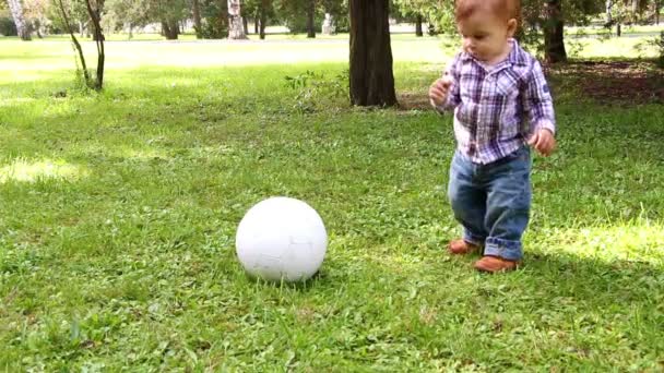 Sevimli küçük çocuk annesi tarafından desteklenen futbol topu ile oynarken - Video, Çekim