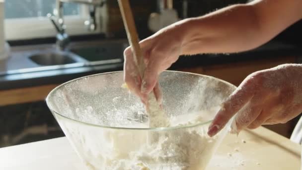 Woman is making dough at home, mixing the ingredients with wooden spoon, preparing some tasty baking, beautiful close up shot, slow motion. - Footage, Video