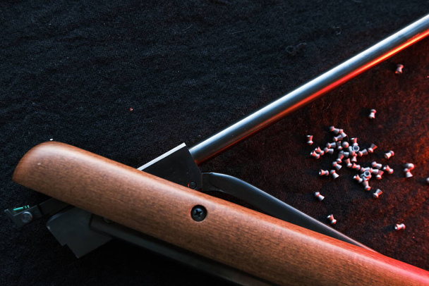 Rifle gun break in two with air pellets for hunting on cloth dark background with red light. - Fotografie, Obrázek