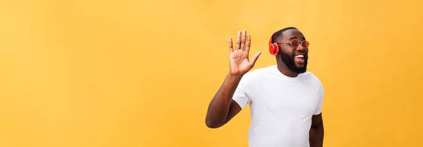 Joven hombre afroamericano con auriculares y disfrutar de la música sobre oro amarillo Fondo
. - Foto, imagen