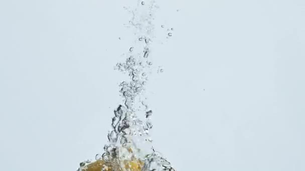 Fruta de limão caindo água em bolhas closeup. Superfície ascendente de citrinos frescos de verão. Saboroso fluxo saltitante de vitamina azeda em líquido cristalino. Alimentação saudável orgânica. Conceito refrescante de bebida de limonada - Filmagem, Vídeo