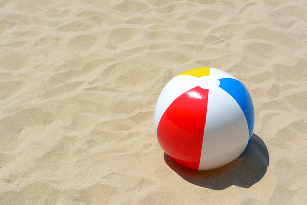 Colorful beach ball on sand, space for text - Фото, зображення