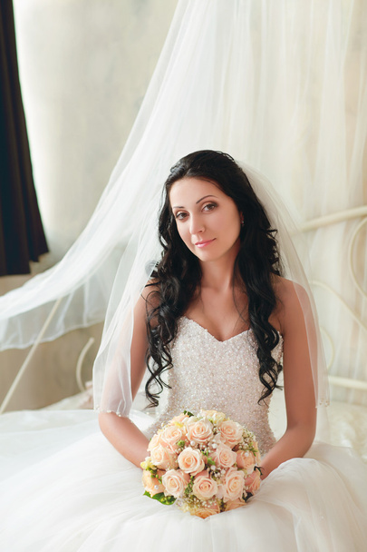Krásná nevěsta sedí s kyticí - Fotografie, Obrázek