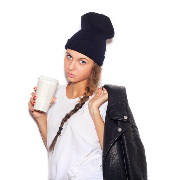 swag girl in black beanie with cup of coffee looking at camera - Fotó, kép