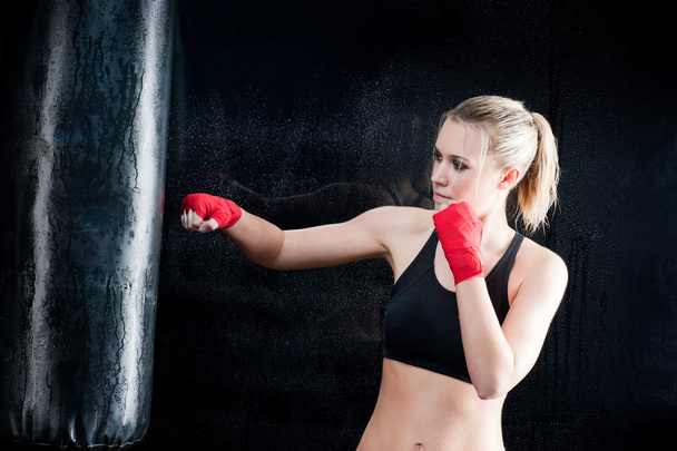 Boxing training woman punching bag in gym - Foto, immagini
