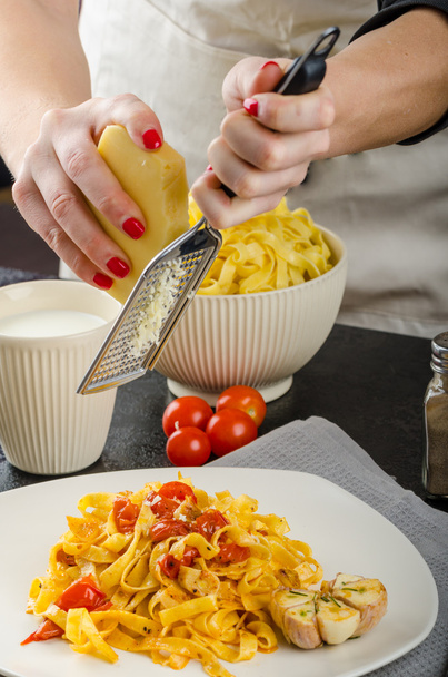Chef prepares tagliatelle with garlic and cherry tomatoes - Zdjęcie, obraz