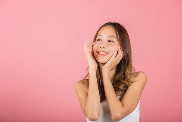 Femininity. Asian beautiful young woman smiling mask cosmetic patches gel under the eyes, Portrait female touching clean skin medical hydrogel eye patch on face, isolated on pink background, skincare - Φωτογραφία, εικόνα