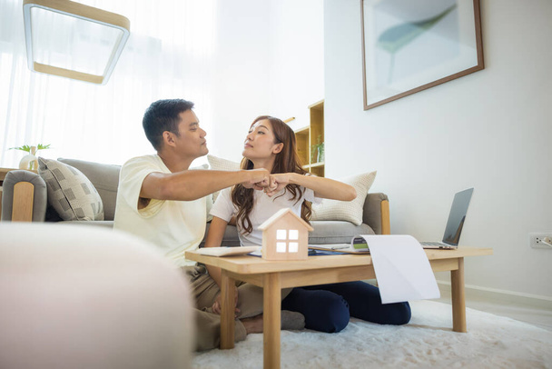Asian couple in home or house. To bump punch, compare prices, interest, credit and calculate together. Include laptop, calculator and document on table. Concept for marriage, family, loan, finance. - Photo, Image