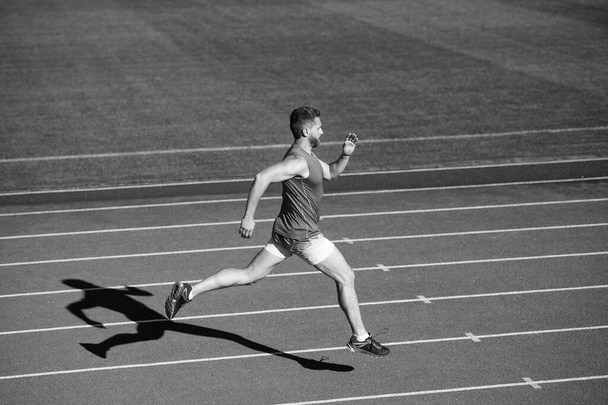 outdoor stadium sprint. physical training. athletic guy run. challenge and competition. marathon speed. sprinter. energetic man on running track. sporty runner. stamina. sport and endurance. - 写真・画像