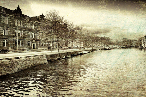 Városi jelenet Amszterdamban tipikus helyi építészettel. Rakpart Amszterdam történelmi központjában, Hollandiában. Vintage stílusú tónusú kép - Fotó, kép