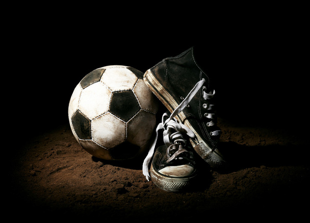 Soccer ball on ground on dark background - 写真・画像