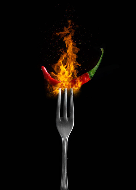 Fresh raw red hot chilli pepper on fork on Black Background  - Foto, afbeelding